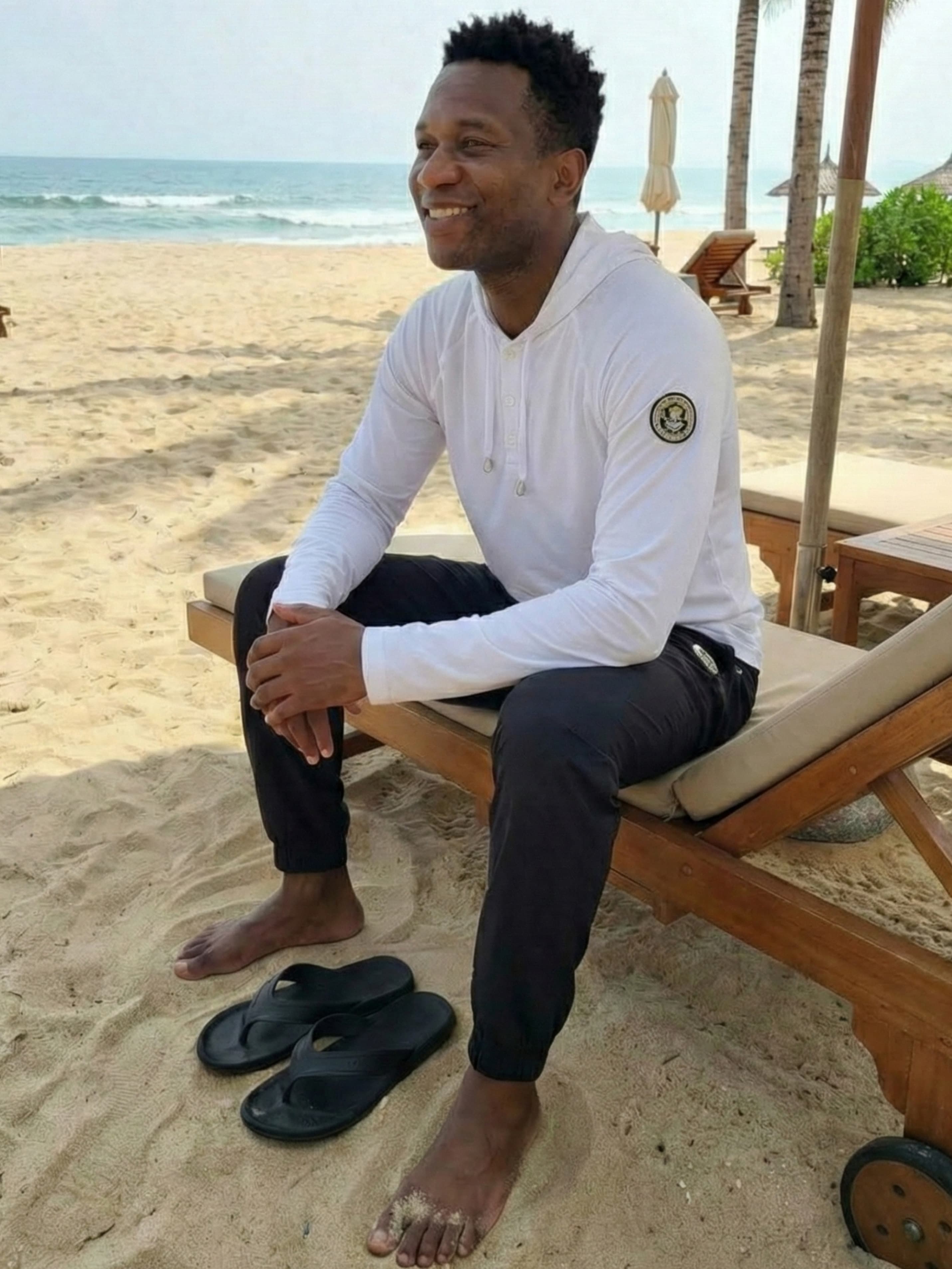 Man in black joggers relaxing at beach