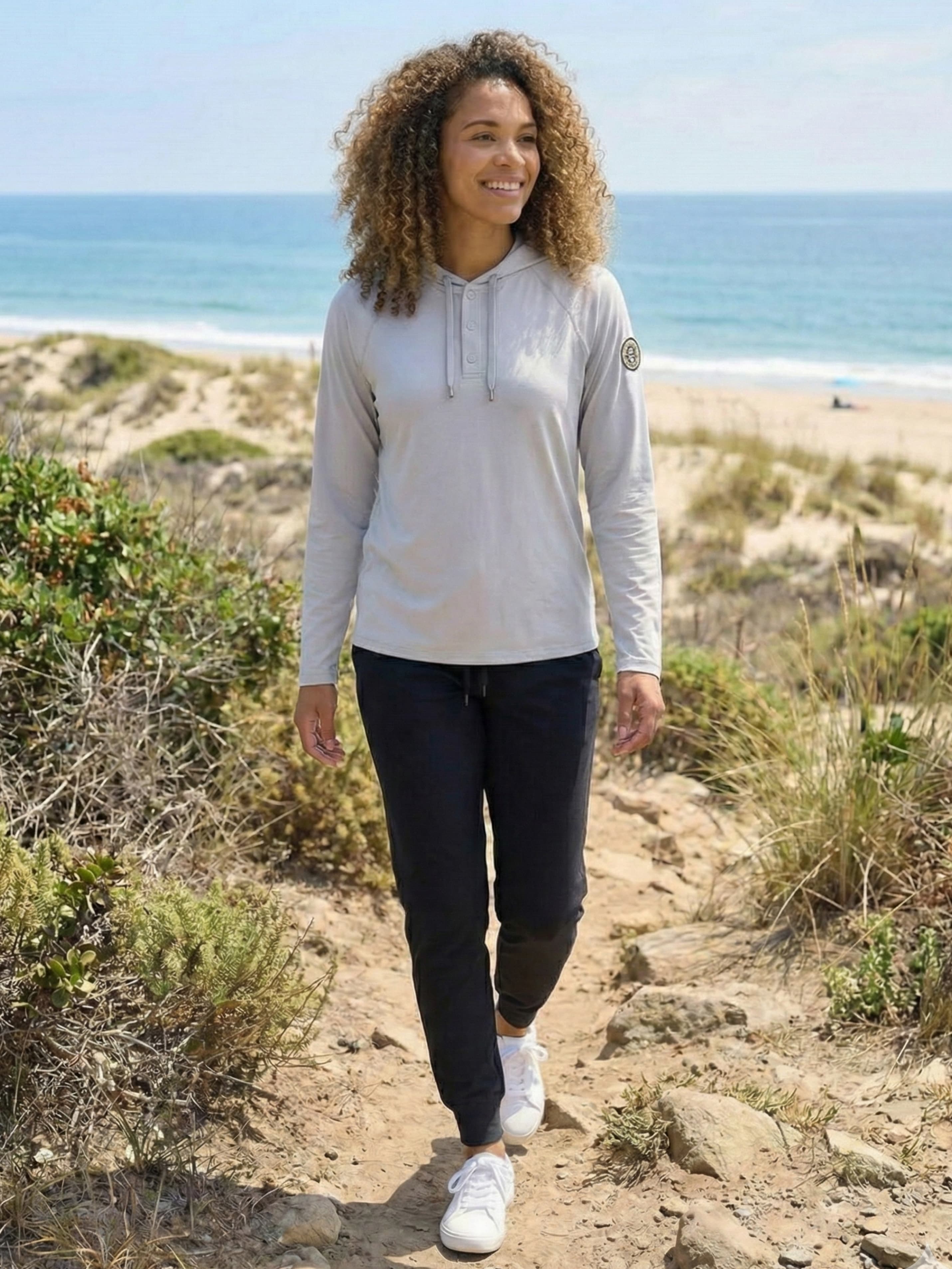 Woman in black joggers walking on coastal hiking trail